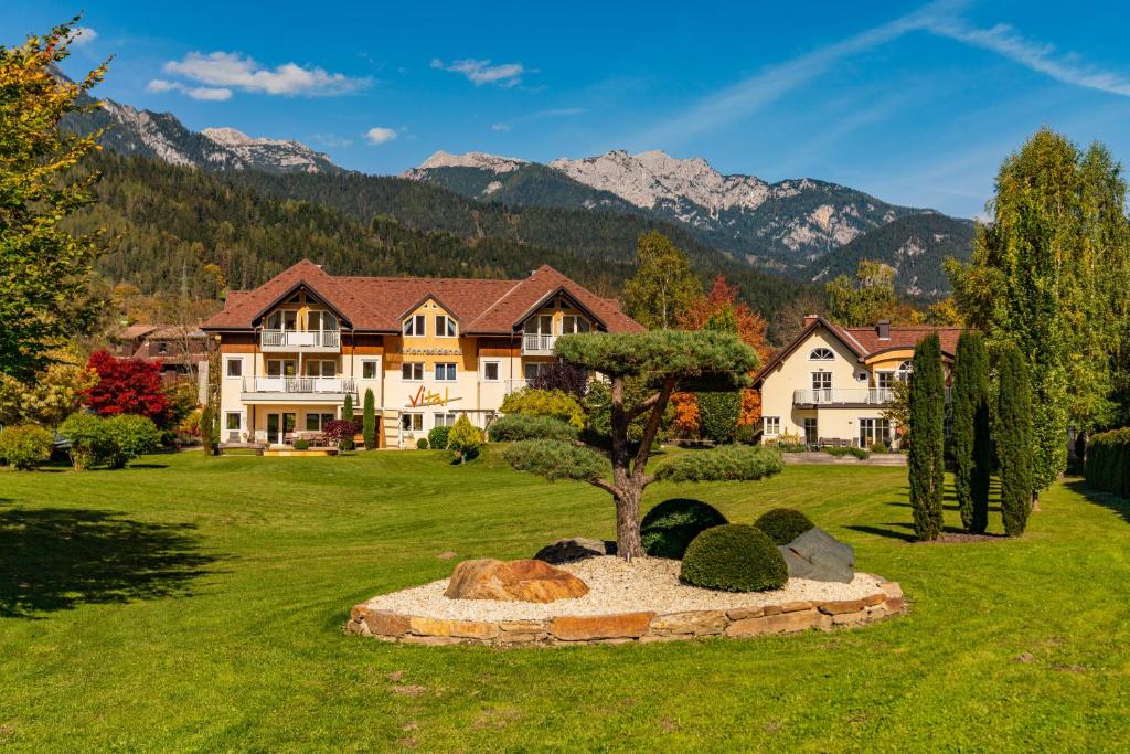 una casa grande con un árbol en medio de un patio en Ferienresidence Vital en Schladming