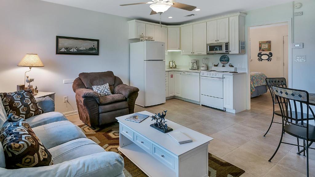 a living room with a couch and a table and a kitchen at Hidden Beach 117 in Santa Rosa Beach