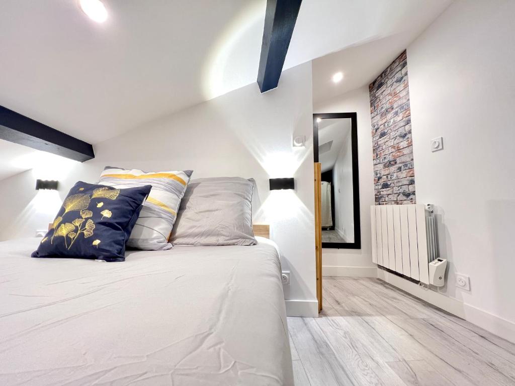 a bedroom with a large white bed with pillows at Le Loft ~ à 4 min de la gare, Fibre + Parking privé in Poitiers