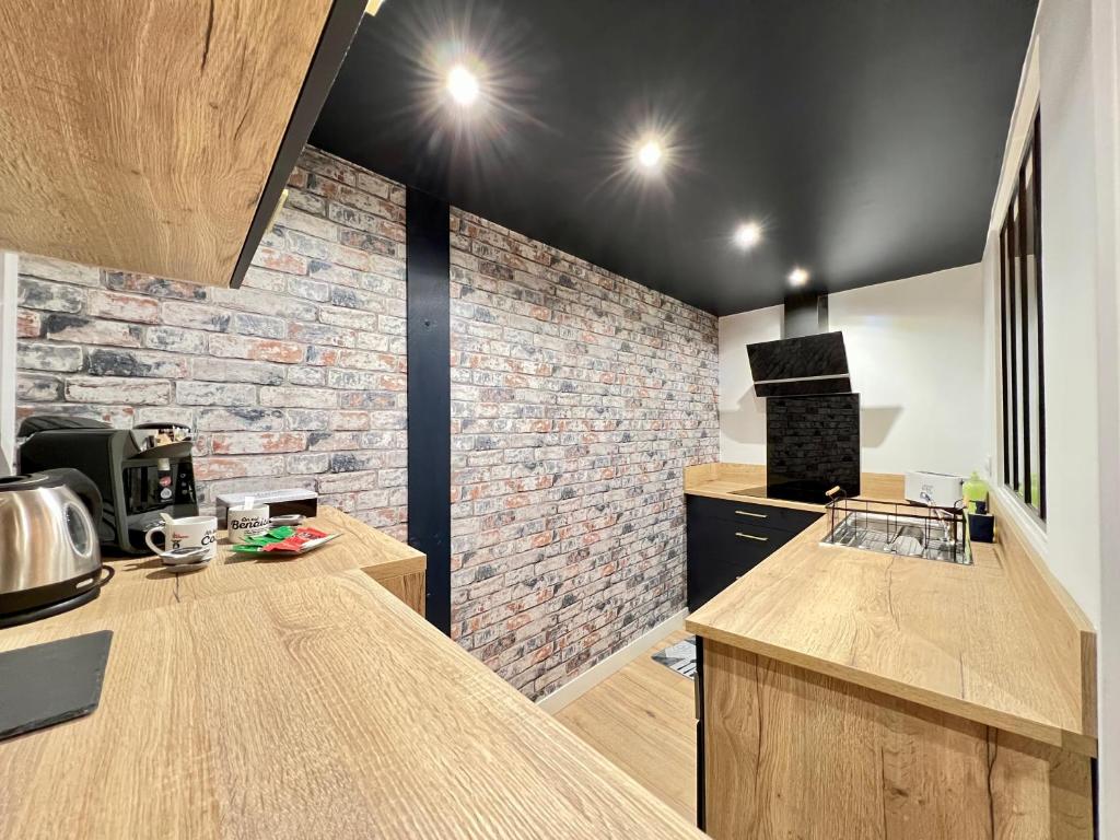 a kitchen with a brick wall and a counter top at Le Loft ~ à 4 min de la gare, Fibre + Parking privé in Poitiers