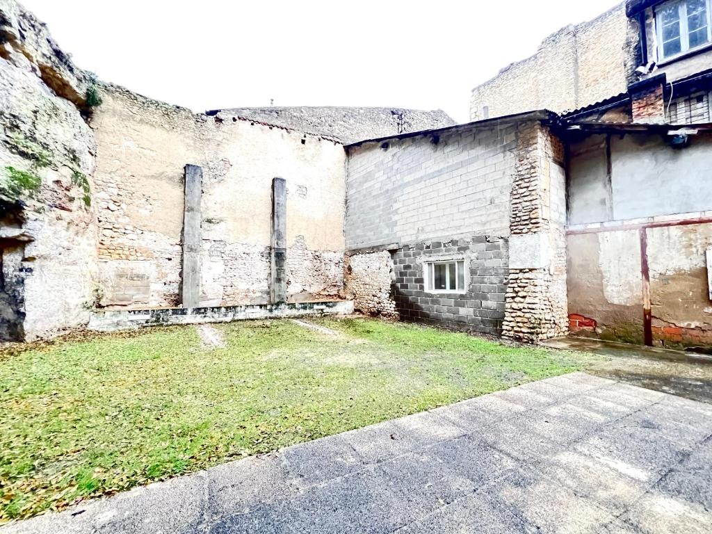 an old brick building with a grass yard in front of it at Le Loft ~ à 4 min de la gare, Fibre + Parking privé in Poitiers
