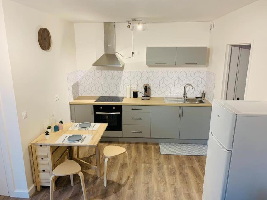 uma cozinha com uma mesa e cadeiras e um lavatório em Gîte meublé 1 à 4 pers à Sierck-Les-Bains proche Cattenom Thionville Luxembourg em Sierck-les-Bains