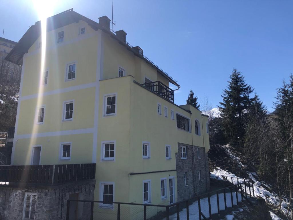 een groot wit gebouw op de top van een berg bij Chalet Badberg in Bad Gastein