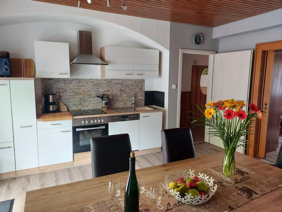 uma cozinha com uma mesa com um vaso de flores em Ferienhaus Heimes em Klotten