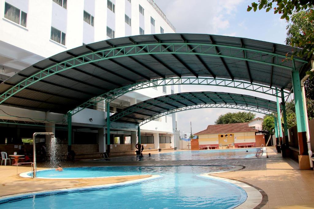 a swimming pool under an archway in a building at Hotel ASRC in Alor Setar