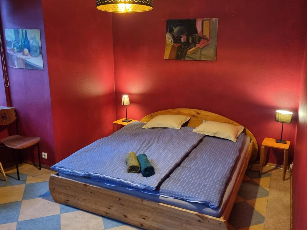 sypialnia z dużym łóżkiem w czerwonej ścianie w obiekcie The Heart of Old Riga w Rydze