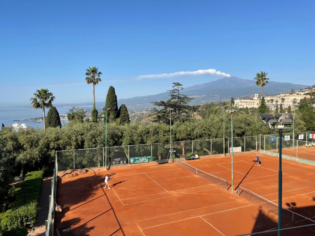 duas pessoas a jogar ténis num campo de ténis em Papiro House em Taormina