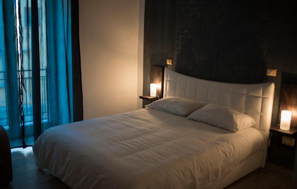 ナポリにあるBHome Fashion Suiteのベッドルーム(白い大型ベッド、ランプ2つ付)