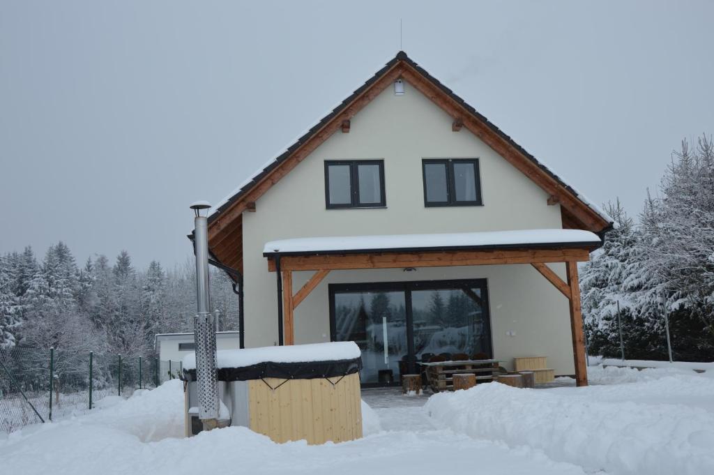 a house with snow on the roof of it at Chata Miki in Boskovice