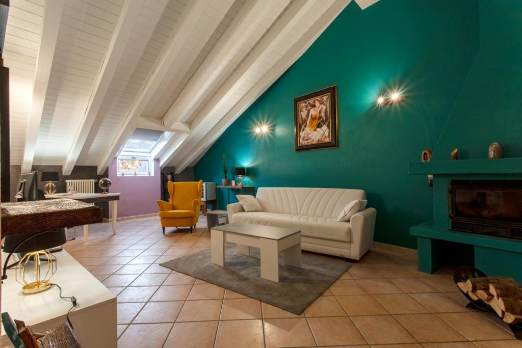 a living room with a white couch and a green wall at MEMA HOLIDAY HOME in Aosta