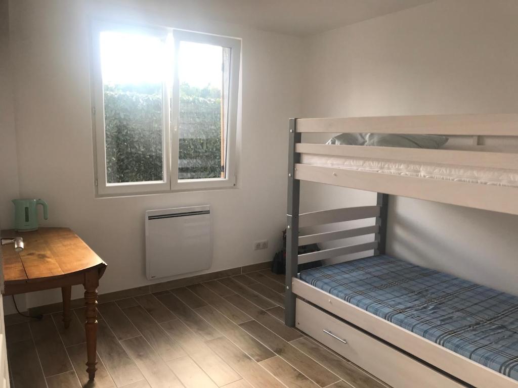 Cette chambre dispose de lits superposés, d'un bureau et d'une fenêtre. dans l'établissement Logement : 2 chambres (5 couchages), salle de bain, à Pierrefitte-sur-Sauldre