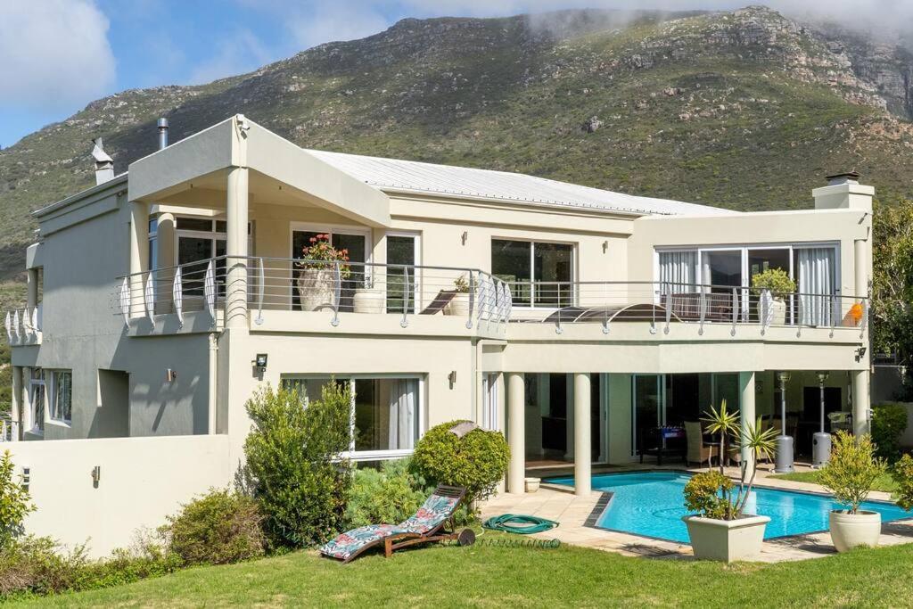 una casa blanca con una colina en el fondo en Villa with exquisite mountain and sea views…, en Ciudad del Cabo