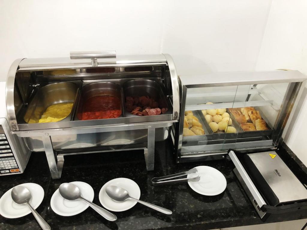 um balcão de cozinha com utensílios e pratos num balcão em Hotel Ceolatto em Várzea Grande