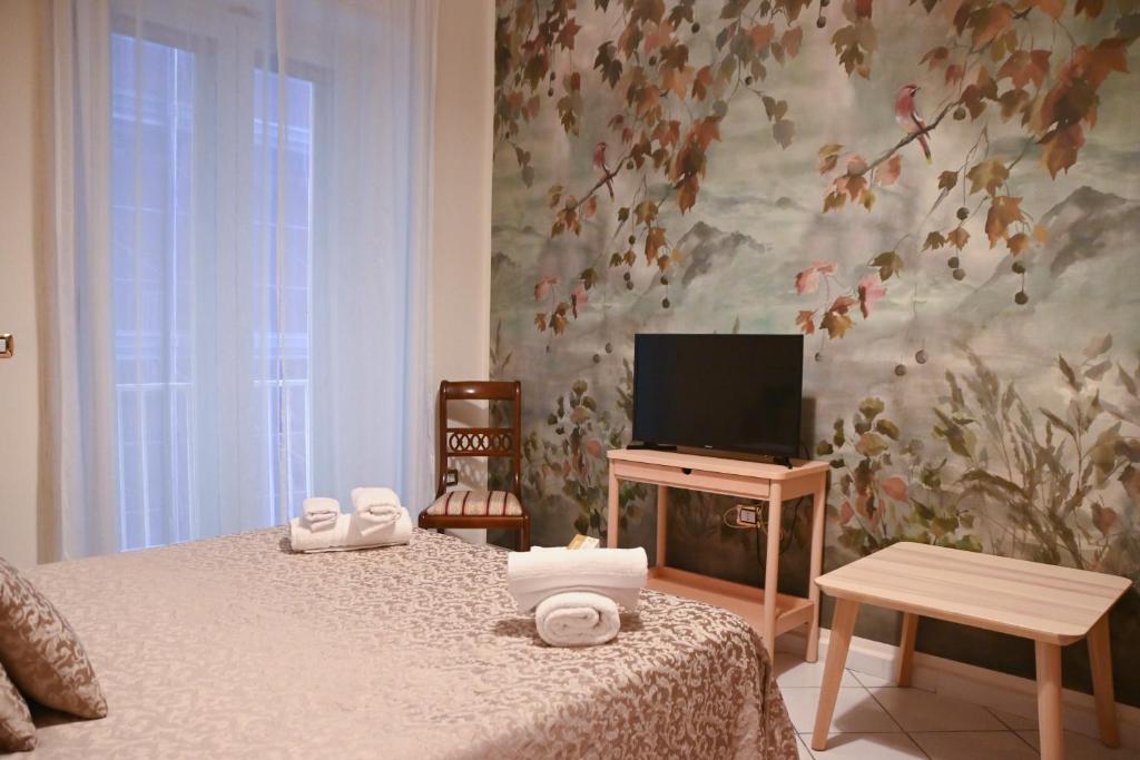 a bedroom with a bed with a tv and a table at Pagina Storica di Napoli in Naples