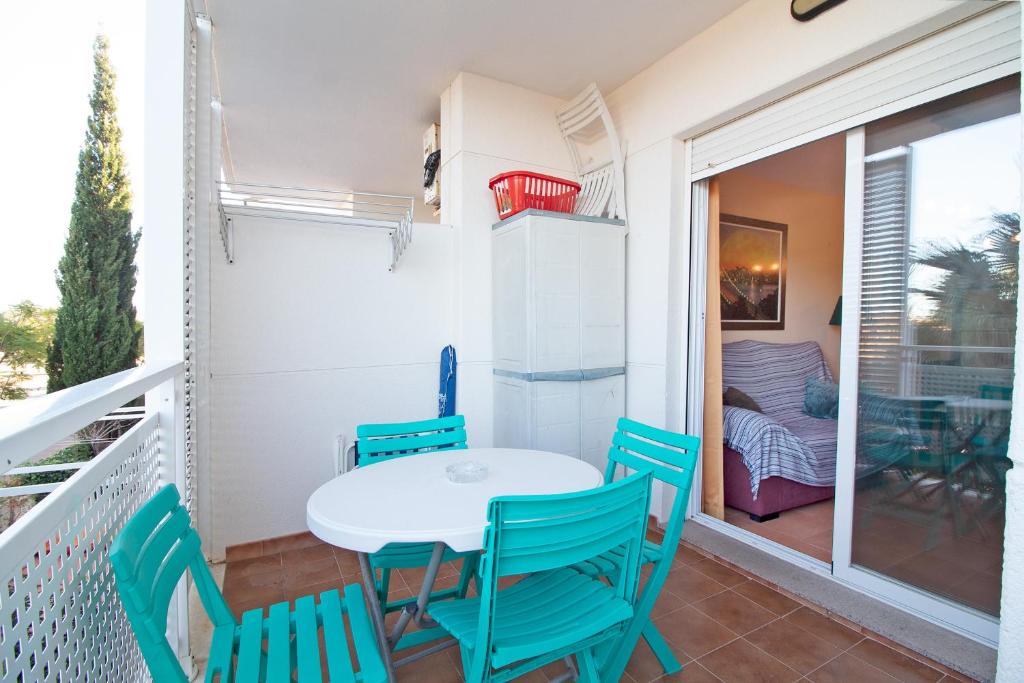 un balcone con tavolo e sedie e una camera da letto di Global Properties, Apartamento en Marjal de Corinto con Piscina a Sagunto