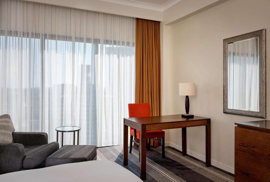 a hotel room with a desk and a couch and a table at Hyatt Regency Birmingham in Birmingham
