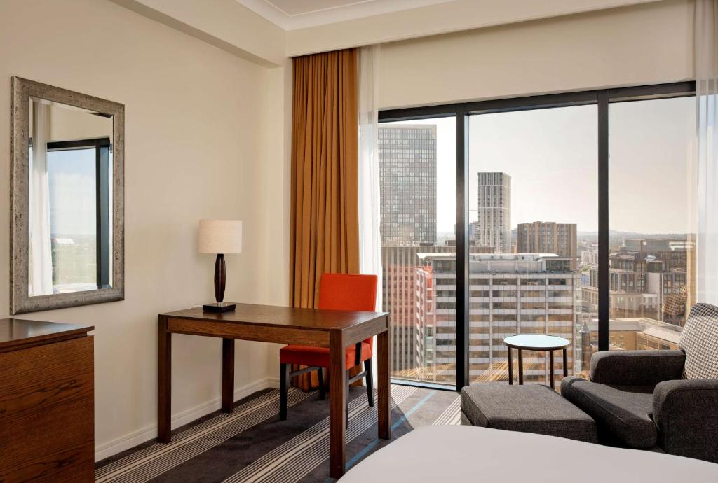 a hotel room with a desk and a large window at Hyatt Regency Birmingham in Birmingham
