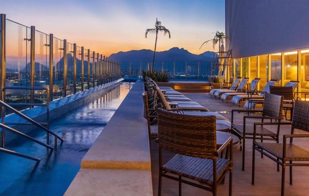 un patio del hotel con sillas y una piscina en Loft em prédio sofisticado, en Río de Janeiro