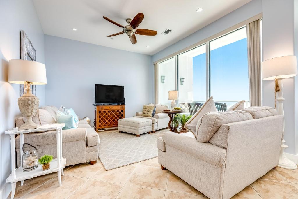 a living room with couches and a ceiling fan at Diamond Beach Resort Seawall Stunner in Galveston
