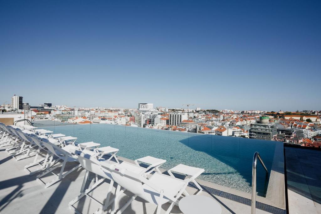 rząd białych leżaków na dachu w obiekcie EPIC SANA Marquês Hotel w Lizbonie