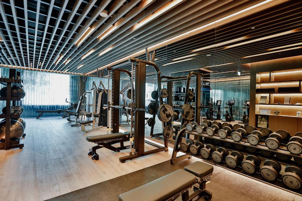 A modern fitness room with free weights, benches and cable equipment.