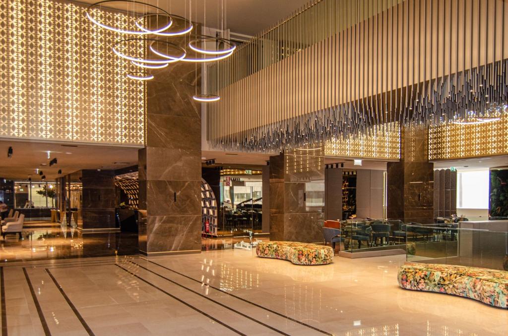 a lobby with tables and chairs in a building at EPIC SANA Marquês Hotel in Lisbon