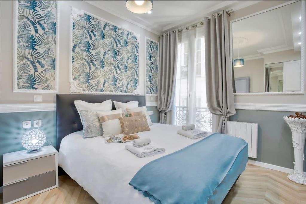 - une chambre bleue et blanche avec un grand lit dans l'établissement Elégant 120m2 3CH quartier Romantique Centre Ville, à Paris