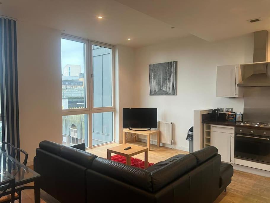 a living room with a black couch and a table at Modern 2BD2Bath Apart CityCentre in Glasgow