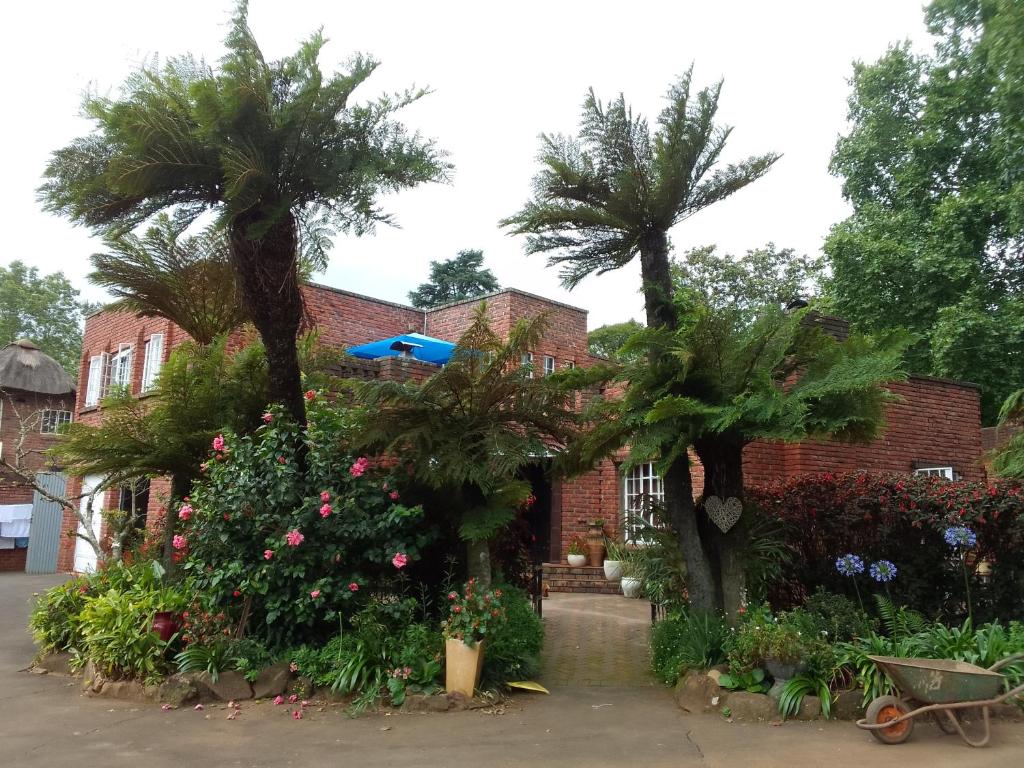 a house with palm trees and flowers in front of it at Hilton Castle in Hilton