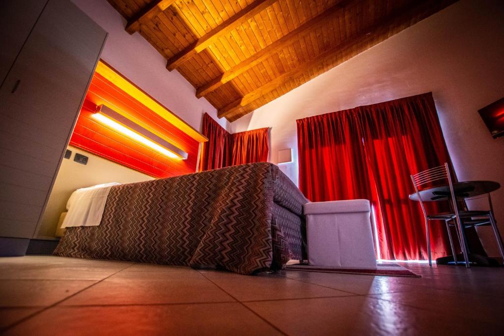 a living room with a couch and red curtains at AgriCamping AlbaVillage Hotel & Wellness in Alba