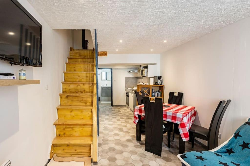 a room with a staircase and a table and a kitchen at Maison atypique dans circulade in Bram