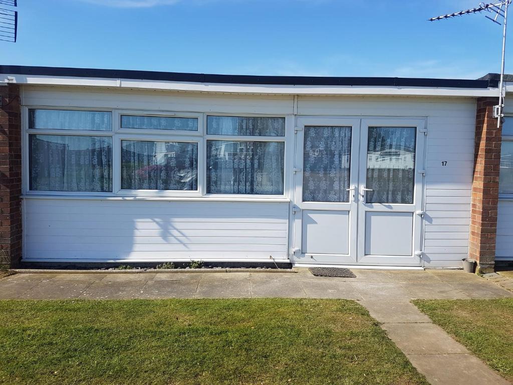 eine Garage mit weißen Türen und Fenstern auf ein Haus in der Unterkunft 17 Breakaway Chalet in Great Yarmouth