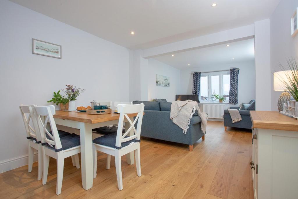 a living room with a table and a blue couch at Shell Cottage in Sidmouth