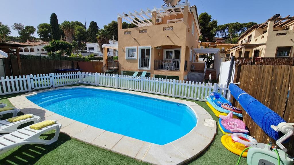 a swimming pool with chaise lounges next to a house at Villa Paraíso in Torremolinos