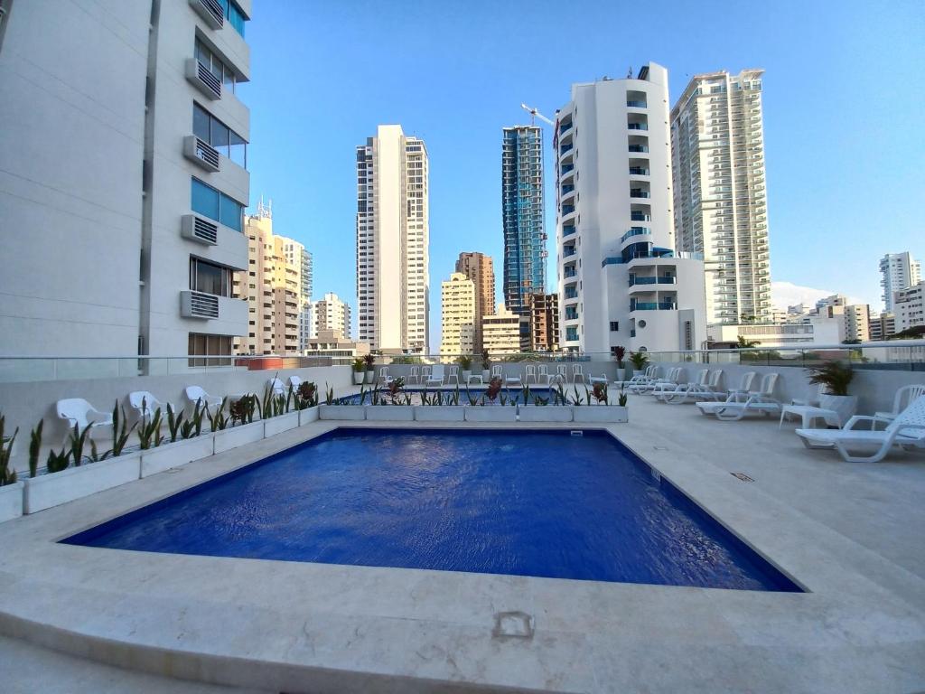 a swimming pool in the middle of a city with buildings at Apt Edificio los Delfines Playa in Cartagena de Indias