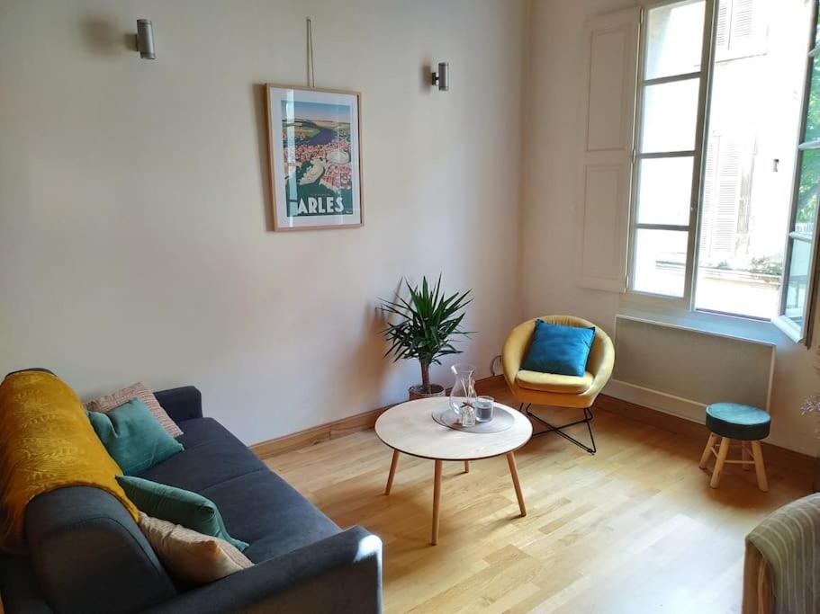 a living room with a blue couch and a table at L' Appart du Centre Historique Charme et confort in Arles