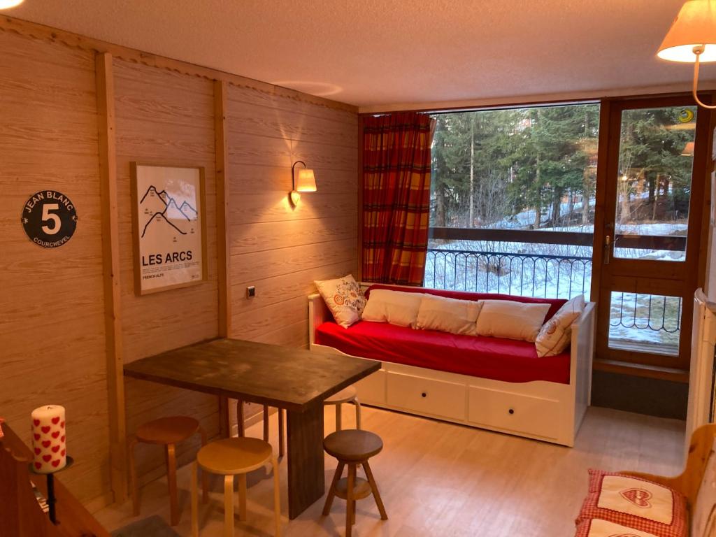 Cette petite chambre comprend un banc, une table et une fenêtre. dans l'établissement Le 104 Miravidi, à Bourg-Saint-Maurice