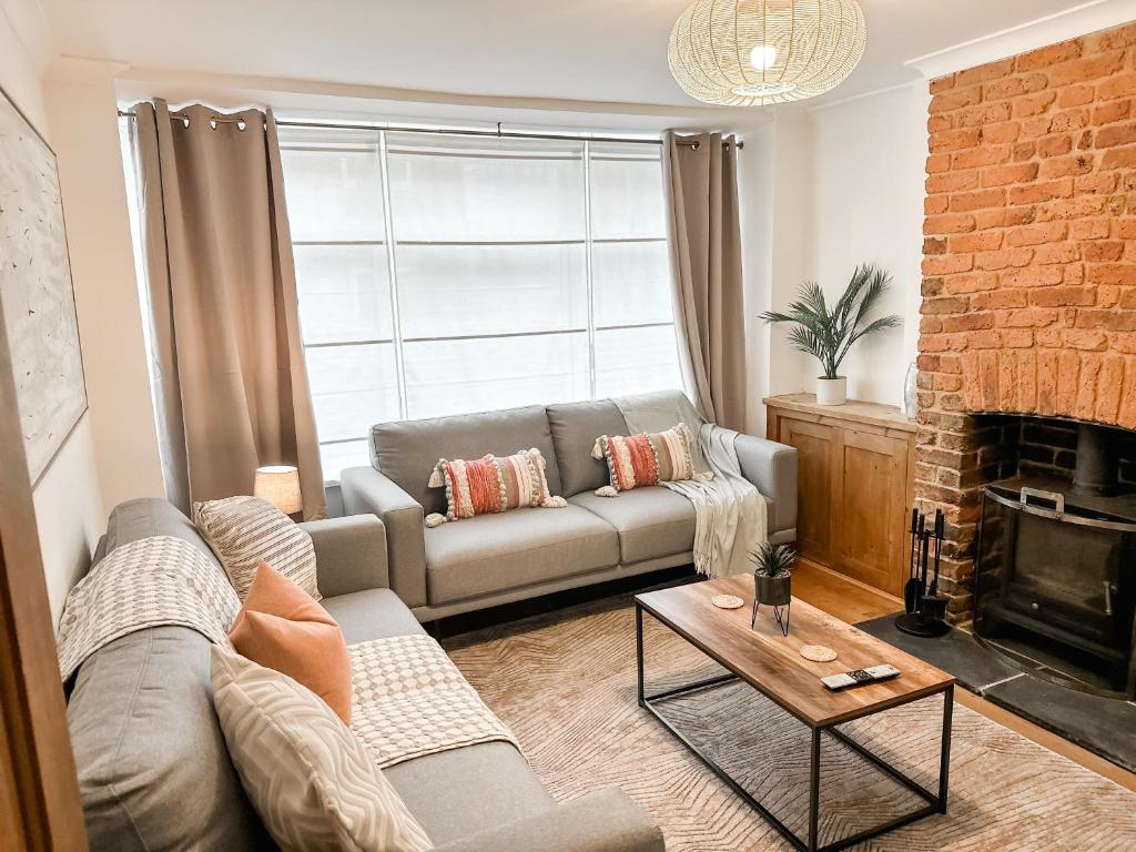 a living room with a couch and a fireplace at 3 Bedroom home close to town centre with WiFi & garden in Royal Tunbridge Wells