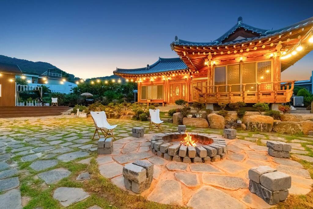 a patio with a fire pit in front of a house at Elon Hanok Pension in Yeosu
