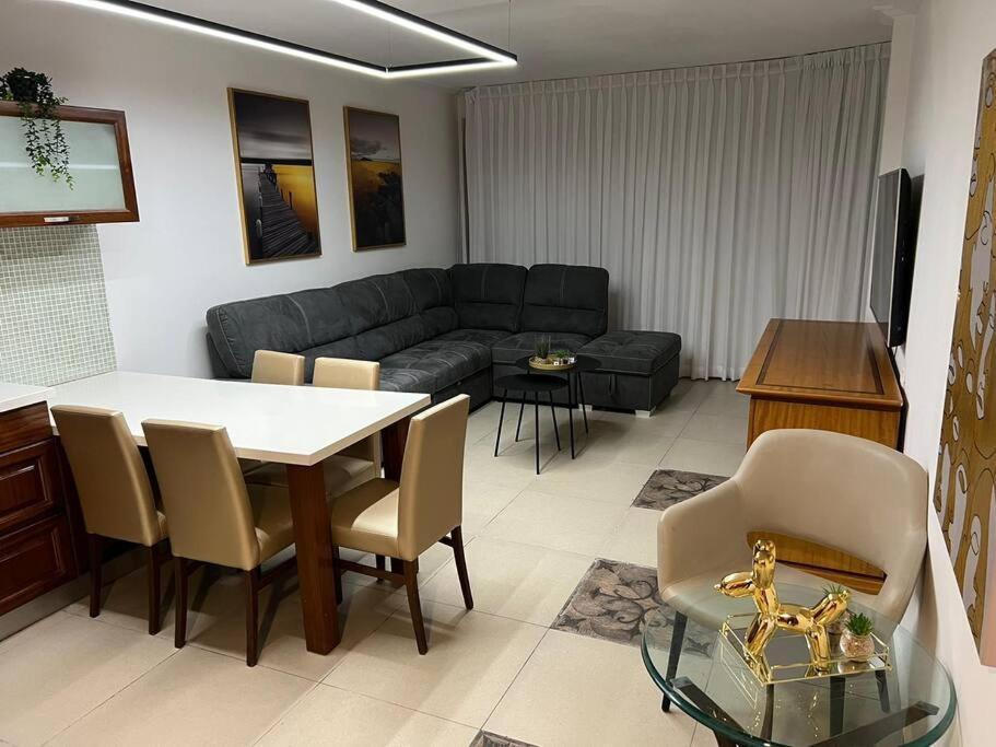 uma sala de estar com um sofá, uma mesa e cadeiras em SuiteSEA em Eilat
