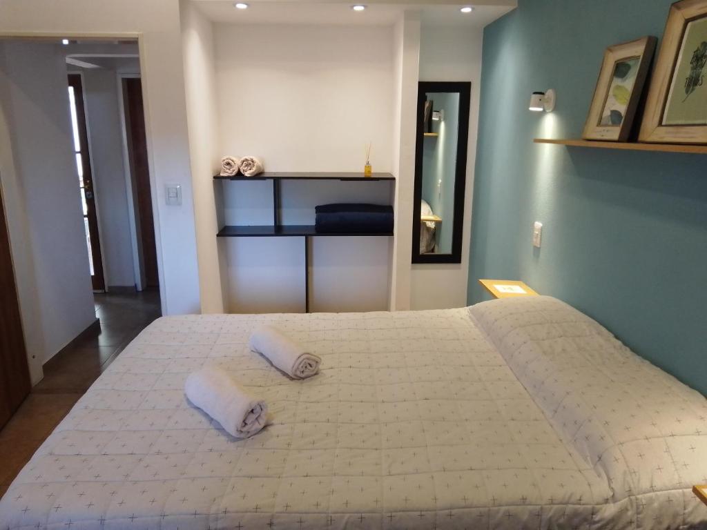 1 cama blanca grande con 2 almohadas en Complejo Quiya - Casa El Algarrobo en Alta Gracia