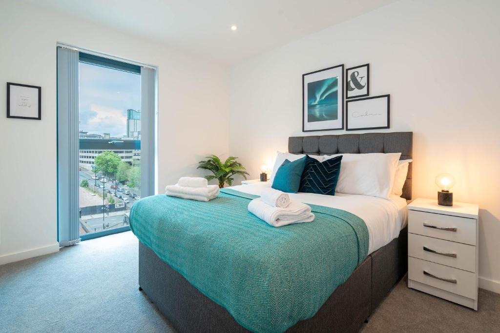 um quarto com uma cama grande e toalhas em Stylish City 1 Bed Apt - Broad St em Birmingham