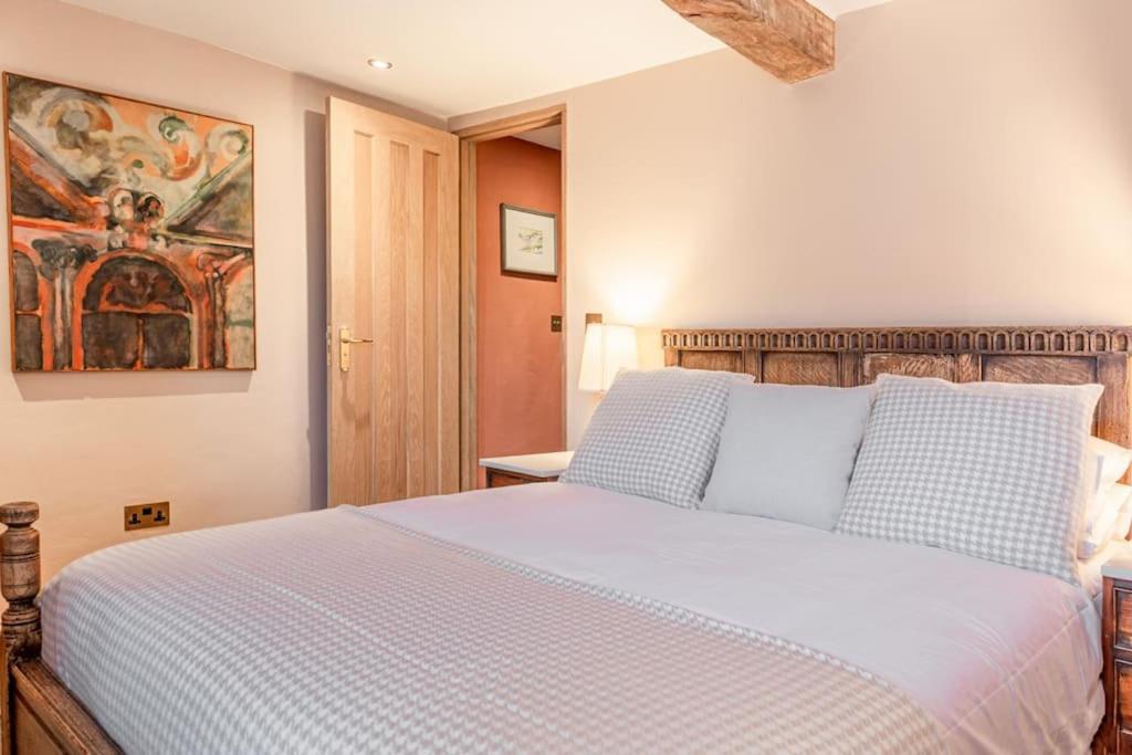 een slaapkamer met een groot wit bed in een kamer bij Luxury Bolthole in the Heart of the Cotswolds in Malmesbury