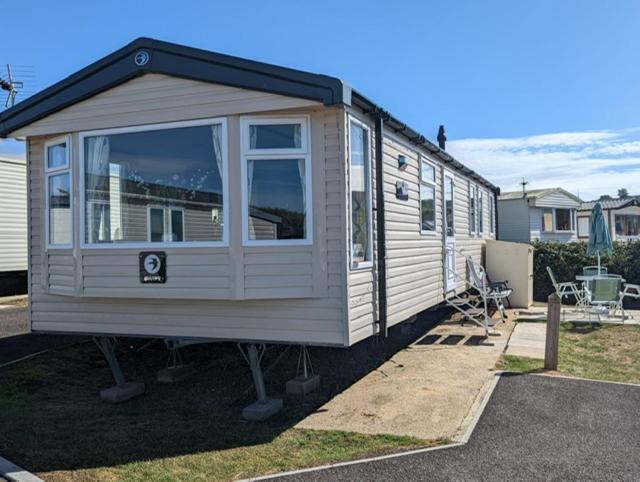 a tiny house is parked in a yard at Sleeps 6 Modern and bright Caravan Littlesea Haven Weymouth in Weymouth