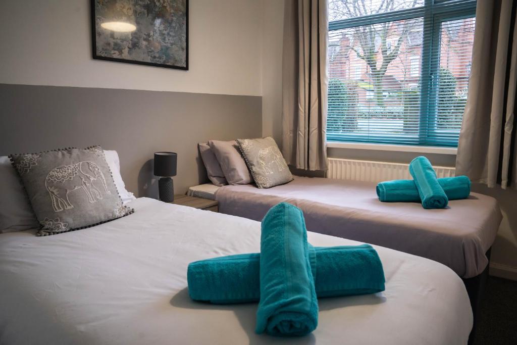 Habitación con 2 camas y almohadas azules. en Fishpond Drive The Park Nottingham, Charming Apartment with FREE PARKING and Walk to City Centre en Nottingham