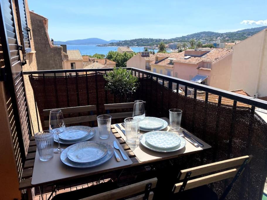 een tafel met borden en glazen op een balkon bij Appart vue mer coeur ville - Casa Riviera Bellevue in Sainte-Maxime
