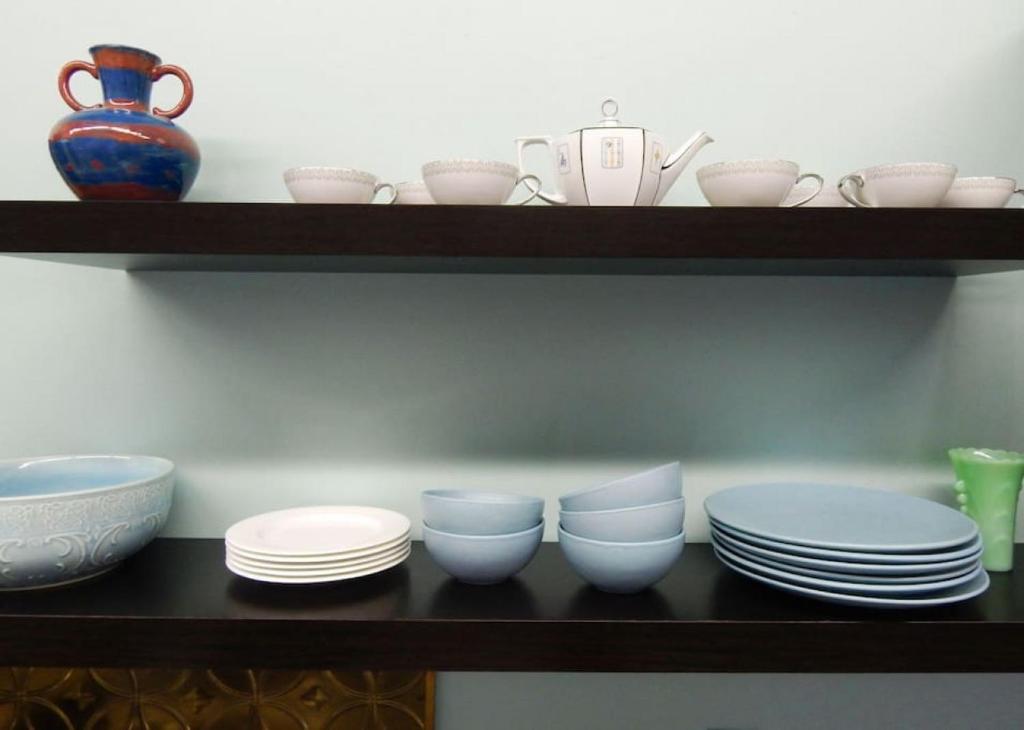 a shelf with plates and bowls and a vase at Riverfront Loft Apt A in Salisbury
