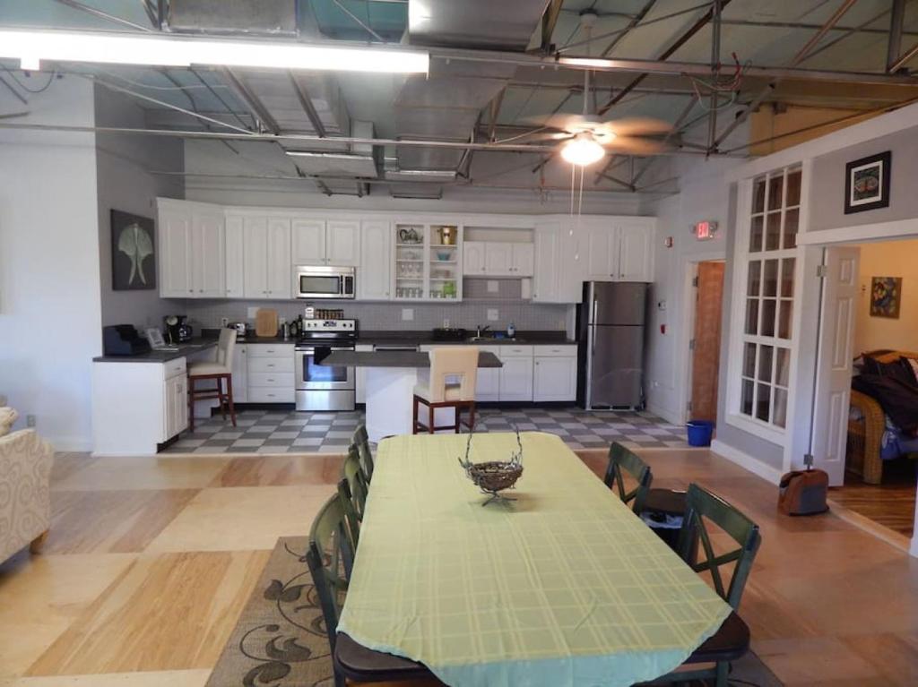 a large kitchen with a table and chairs in it at Corner loft with river views in Salisbury