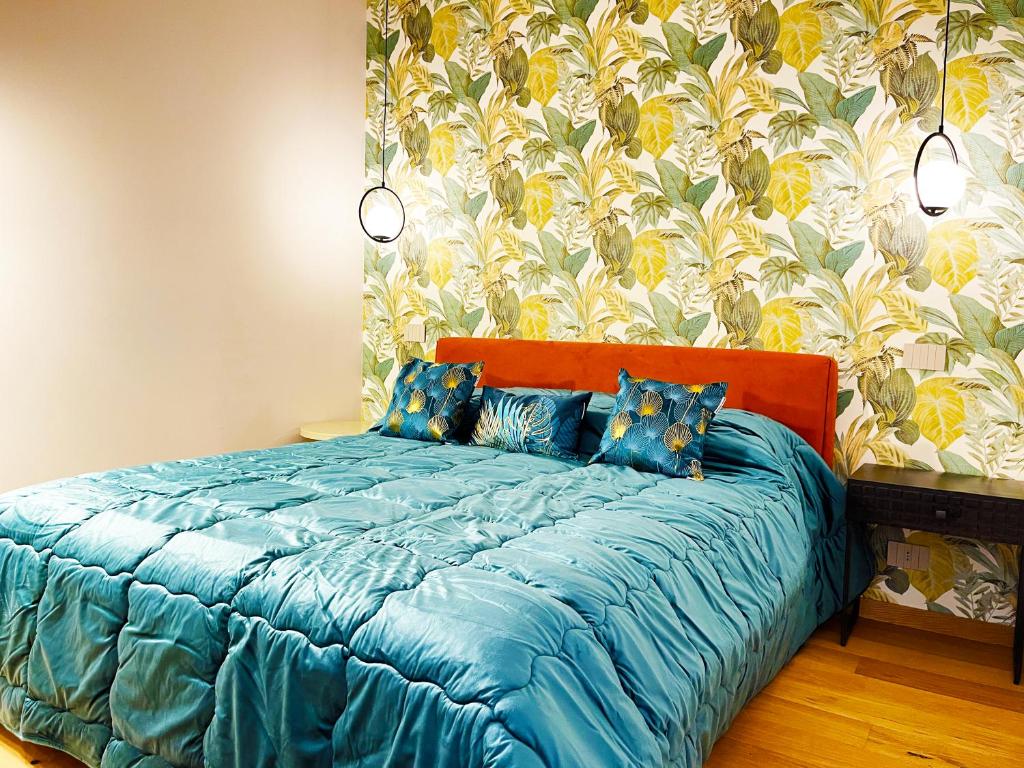 a bed with a blue comforter in a bedroom at Agrigento Boutique Apartments in Agrigento