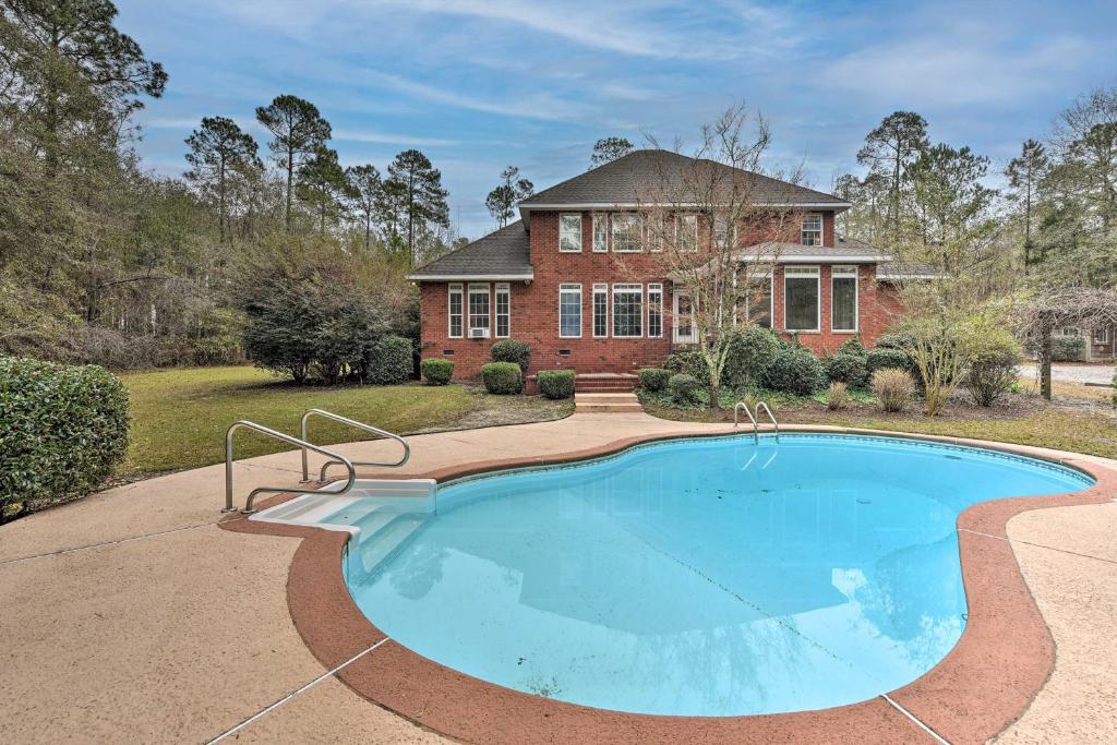 a home with a swimming pool in front of a house at Spacious Statesboro House with Private Pool! in Statesboro